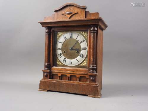 An oak cased mantel clock with brass and white enamelled dia...