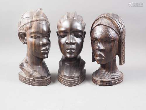 Three mid 20th century Nigerian carved ebony heads, 11 high