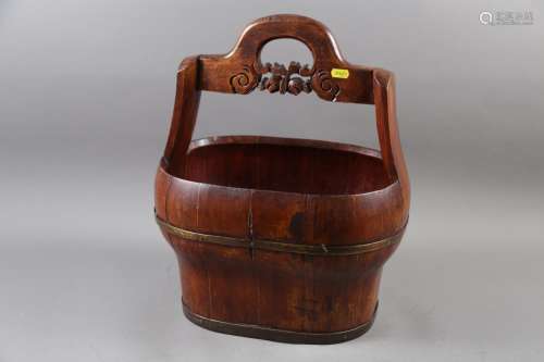 A Chinese hardwood and brass mounted bucket with carved hand...
