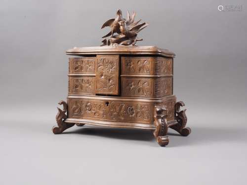 A carved Black Forest jewellery box, the lid carved with two...