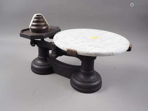 A cast iron cheese balance with marble effect top and weight...