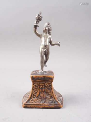 A cast white metal figure of a putto holding a covered goble...