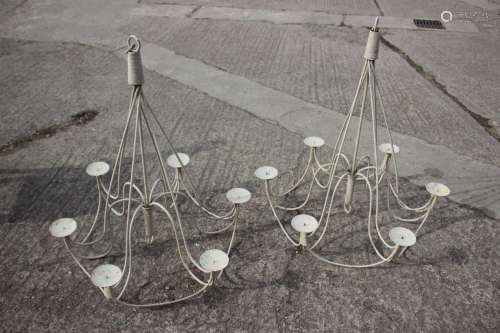 A pair of cream painted wrought iron six-light candelabra