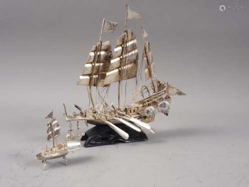 A Chinese white metal model of a sampan, on carved wooden ba...