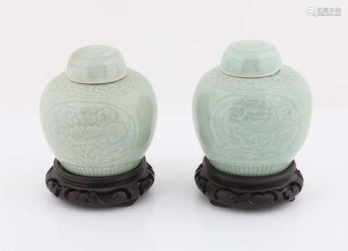 A pair of Chinese celadon jars and covers with underglaze dr...