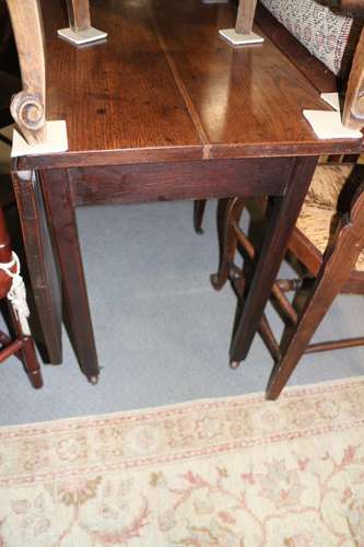 A Georgian oak drop leaf dining table, on moulded chamfered ...