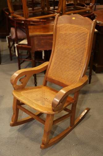 A Kashmir walnut scroll arm rocking chair with cane seat and...