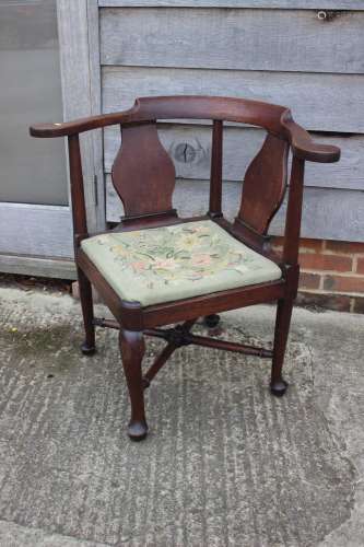 A Georgian oak provincial corner elbow chair with needlework...