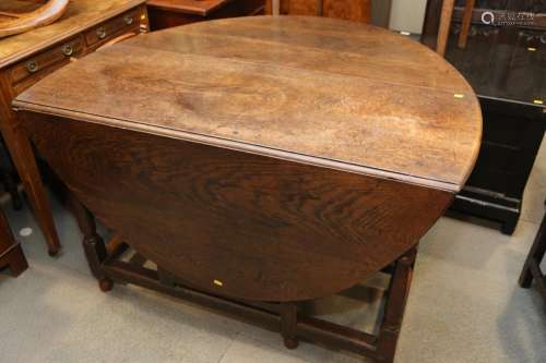 A 19th century oak oval gate leg dining table, on turned and...