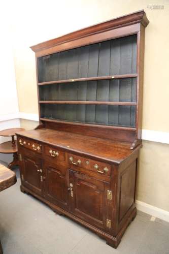A George III oak dresser, fitted shelves over three drawers ...