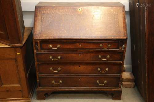 A Georgian oak and mahogany banded fall front bureau, fitted...