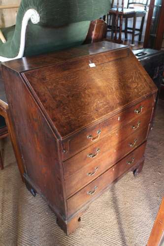 A late Georgian provincial oak fall front bureau with fitted...