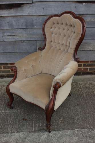 A Victorian walnut showframe armchair, upholstered in a mush...