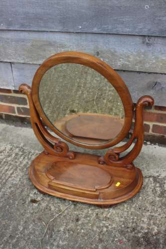 An oval swing frame toilet mirror with plateau base, fitted ...