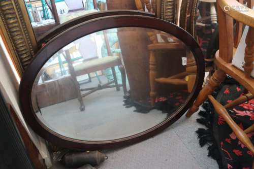 An oak oval framed wall mirror with bevelled plate, 31 x 22