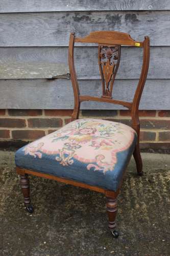 An Edwardian rosewood and inlaid splat back nursing chair wi...