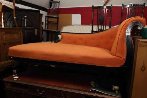 An early 20th century ebonised frame chaise longue, on turne...