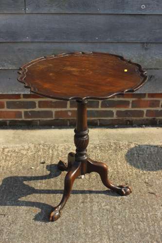 A mahogany pie crust tilt top occasional table, on turned co...