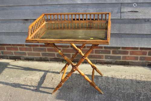 A butlers satin birch spindle galleried tray with brass base...