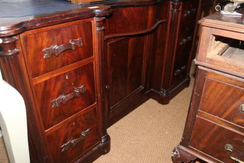 A mahogany serpentine front desk with tooled lined top, fitt...