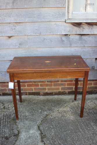 A mahogany and banded and inlaid fold-over top card table, o...
