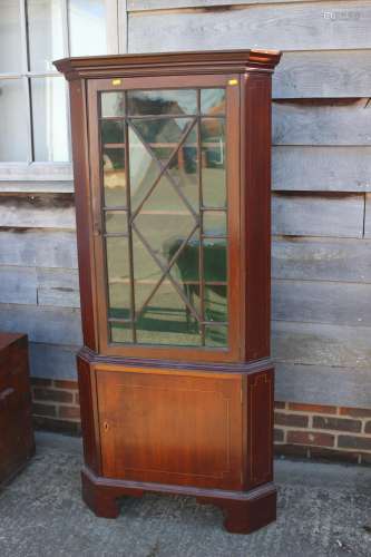 A mahogany two-section corner display cabinet, the upper sec...