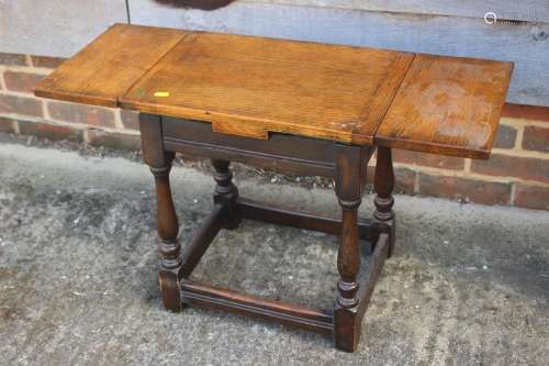 An oak draw leaf top stool, on turned and stretchered suppor...