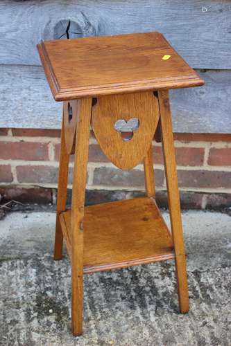 A light oak two-tier occasional table with pierced trefoil d...