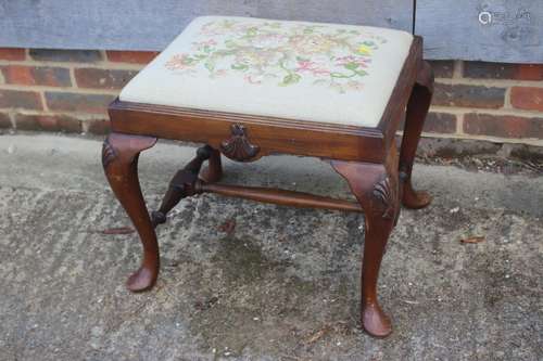 A walnut stool of early Georgian design with needlepoint dro...