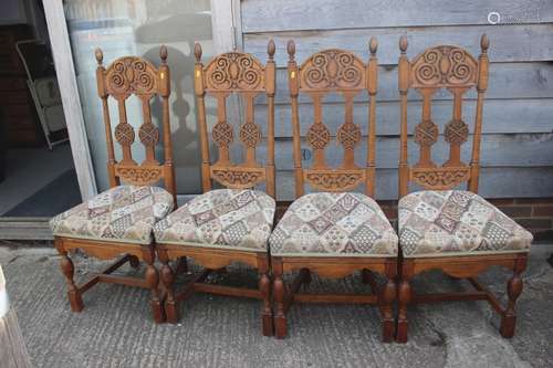 A set of four carved light oak high backed dining chairs wit...