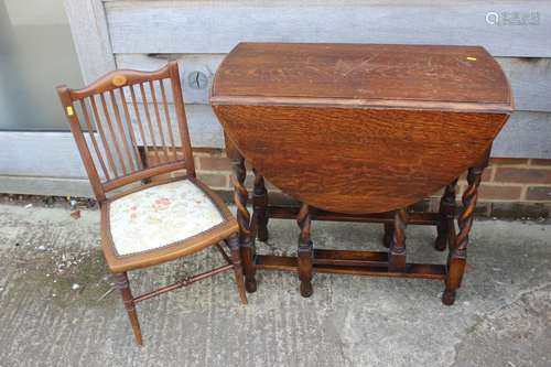 A dark oak drop leaf table, on barley twist supports, 29 3/4...