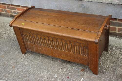 An oak coffer of early 17th century design with shaped top a...