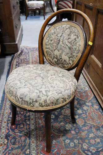 A childs bentwood chair with seat and back upholstered in a ...