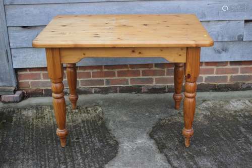 A waxed pine table, on turned supports, 40 wide x 28 deep x ...