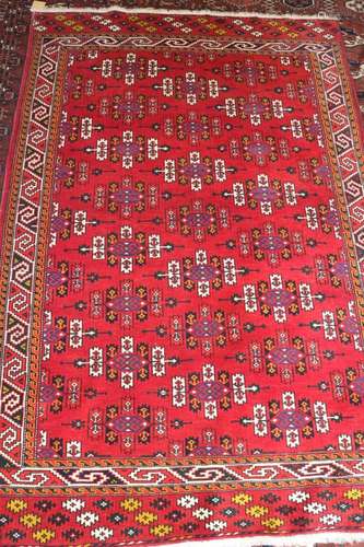 A Caucasian rug with shaped guls, on a red ground and multi-...