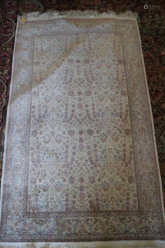 A Qum silk rug with all-over garden design in shades of crea...
