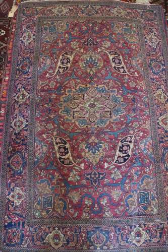 A Kerman rug with scroll and tendril design and central meda...
