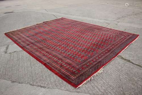 A Bokhara carpet of traditional design with numerous octagon...