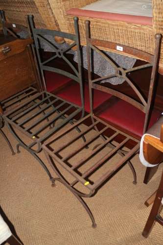 A set of four wrought iron garden chairs with slatted seats,...