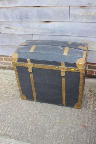 A brass bound dome top trunk with wrought iron carry handles...