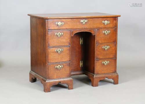 A George III provincial oak kneehole desk, fitted with an ar...