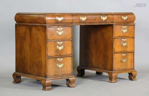 An early 20th century walnut twin pedestal desk, the top ins...