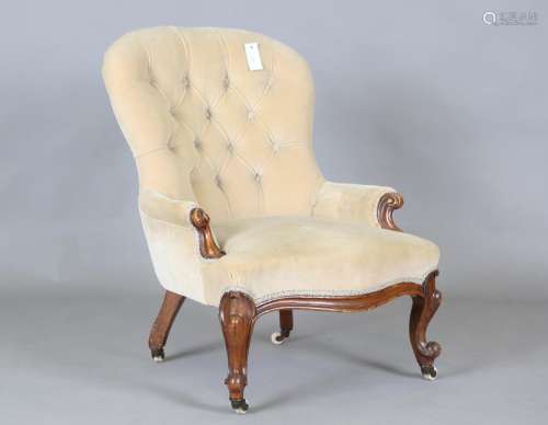 A mid-Victorian walnut framed button back armchair with carv...
