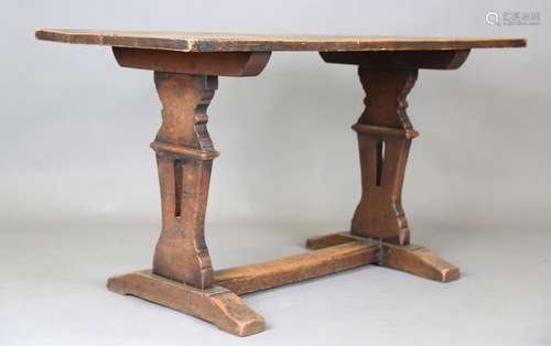 An early 20th century oak tavern table, raised on a pair of ...