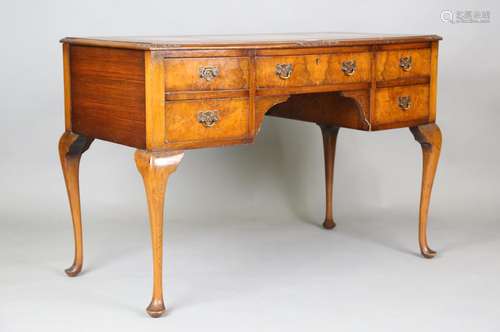 An early 20th century walnut bowfront writing table, raised ...