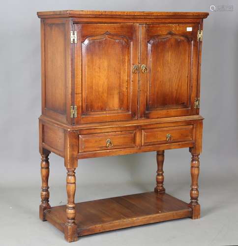 A modern Jacobean style oak side cabinet, height 136cm, widt...