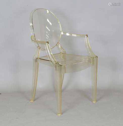 A modern Louis Ghost yellow-tinted polycarbonate armchair ma...