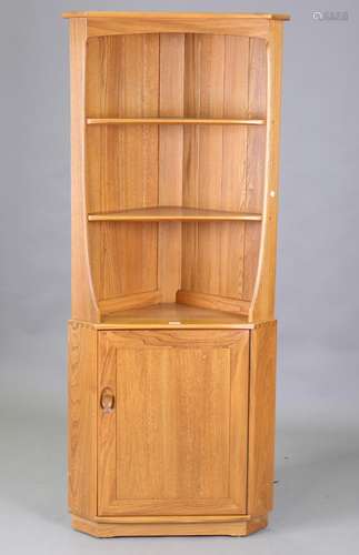 A Ercol elm corner unit, fitted with shelves above a cupboar...