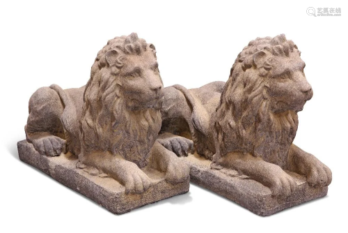 A PAIR OF RECONSTITUTED STONE LIONS, each lying recumbent on...