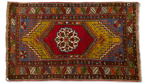 A TURKISH RUG, hand-knotted and multicoloured, the dark red ...